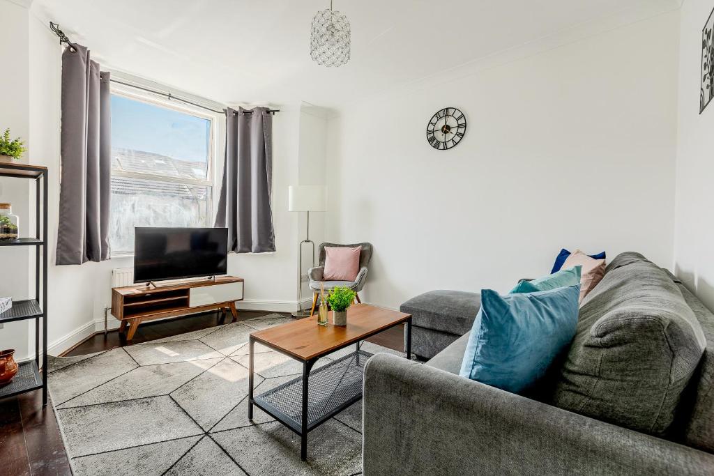 Hotel Cosy flat with free parking near London hotspots, a living room with a couch and a tv at Cosy flat with free parking near London hotspots in London