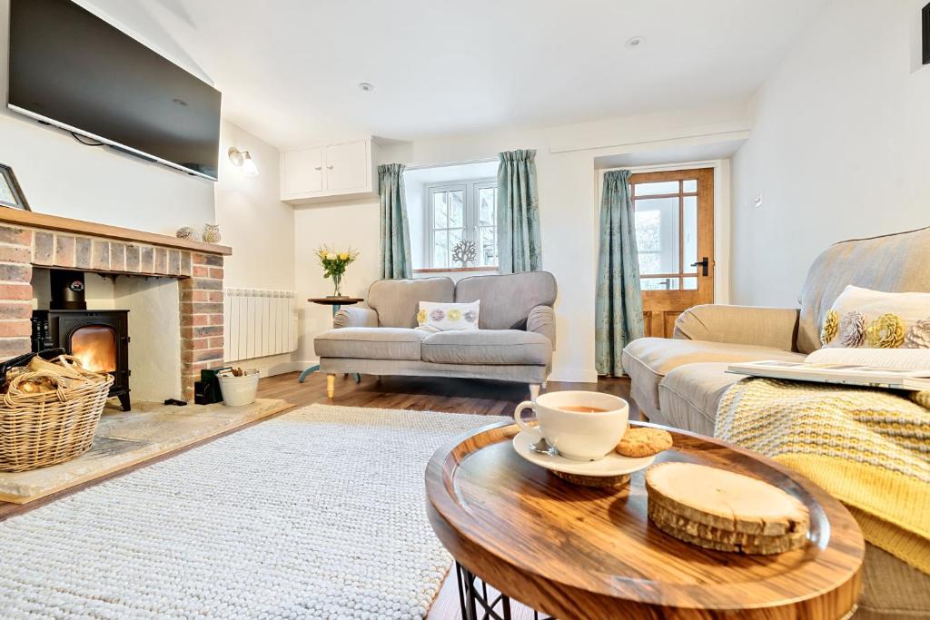 a living room with a couch and a table at Woodcutter's Cottage in Dorchester