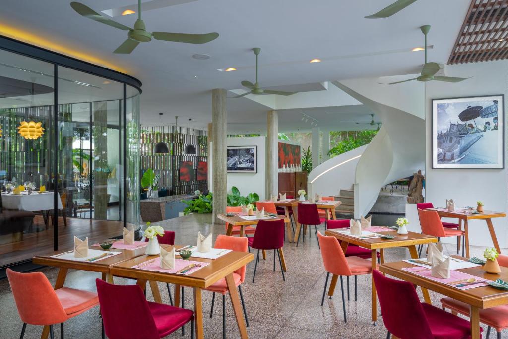 a restaurant with wooden tables and red chairs at Viroth's Hotel in Siem Reap