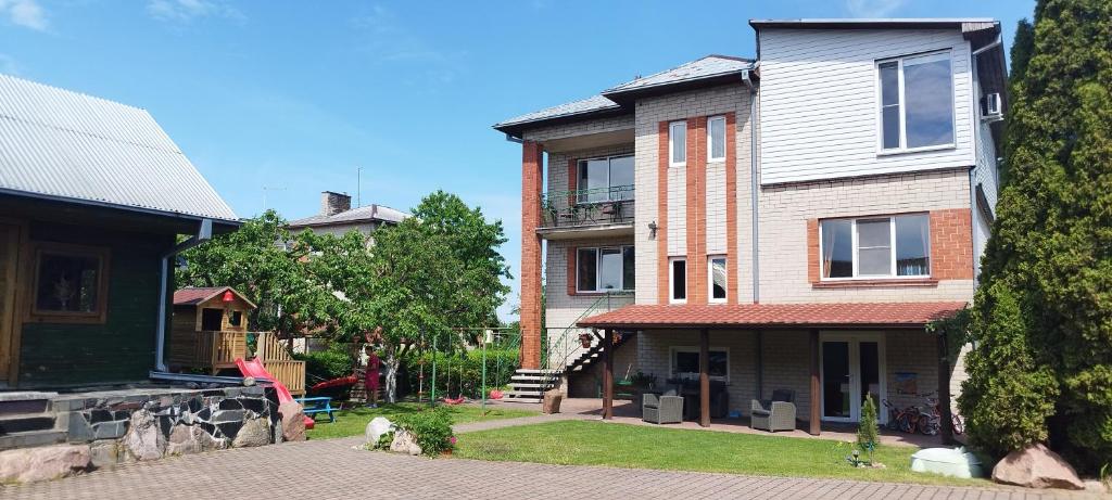 a large brick house on a street at Spacious & Cozy Apartment with Forest View in Zapyškis
