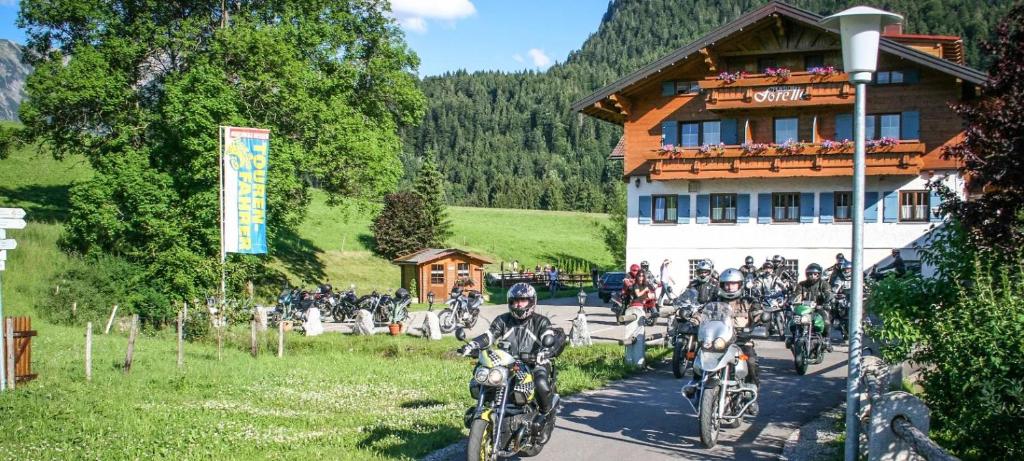 a group of people riding motorcycles in front of a building at Ferienpension Forelle in Obermaiselstein