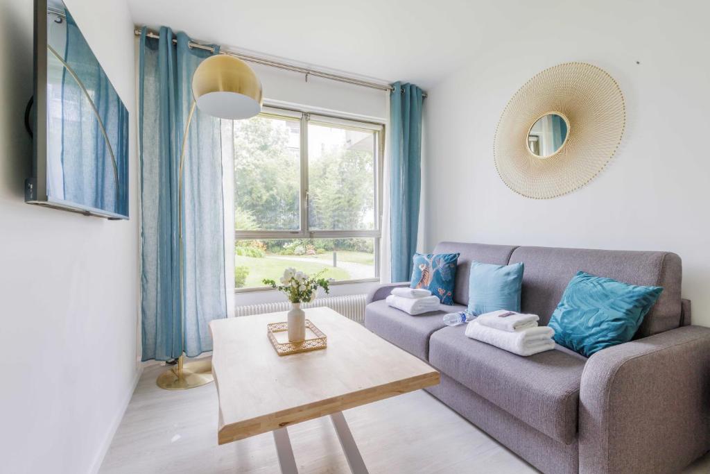 un salon avec un canapé et une table dans l'établissement Wonderful studio - 2P - Neuilly-sur-Seine, à Neuilly-sur-Seine