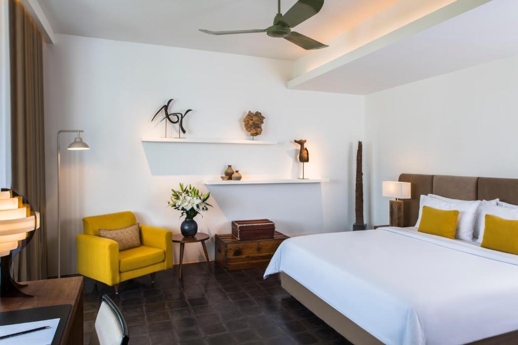 a bedroom with a bed and a yellow chair at Viroth's Hotel in Siem Reap