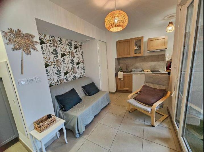 a small living room with a couch and a chair at Au petit coeur de l'isle in LʼIsle-sur-la-Sorgue