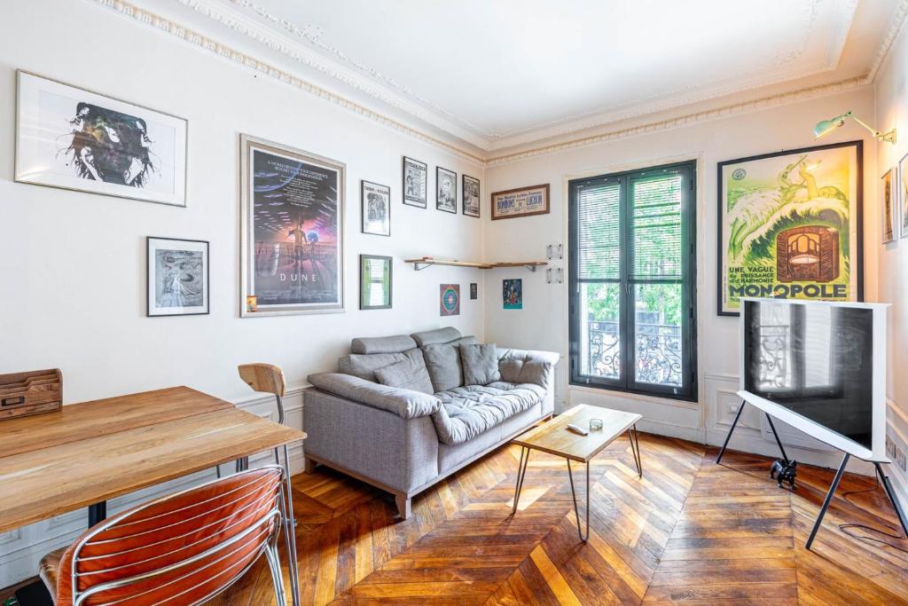 un salon avec un canapé et une télévision à écran plat dans l'établissement GuestReady - Apt. Charmant près Parc André Citroën, à Paris