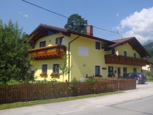 a yellow house with a wooden fence in front of it at Haus Fuchs in Haus im Ennstal
