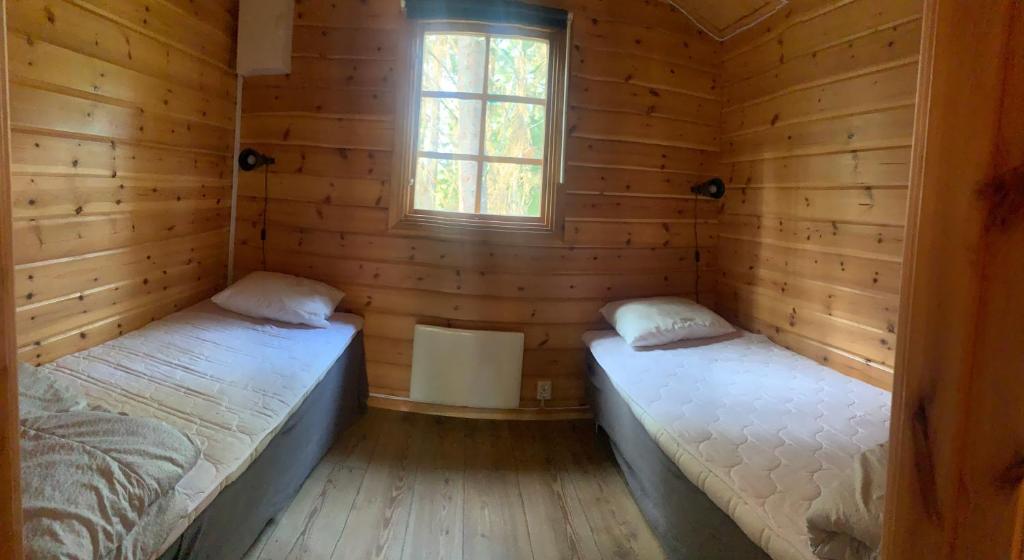 SöderbouddGistholmen的小木屋内的两张床,设有窗户