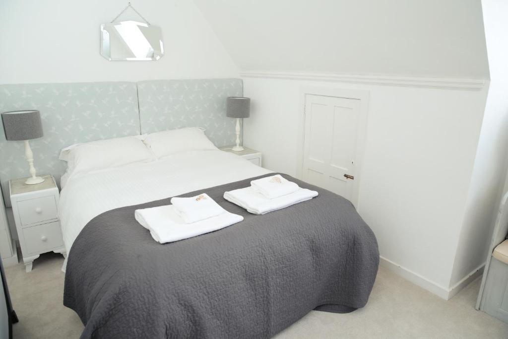 a bedroom with a bed with two towels on it at Divine in Georgeham