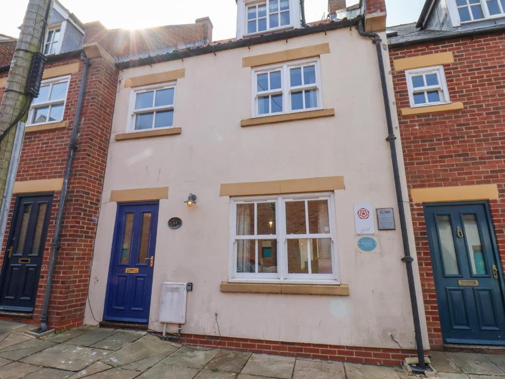 a house with blue doors on a street at Adventure Cottage in Whitby