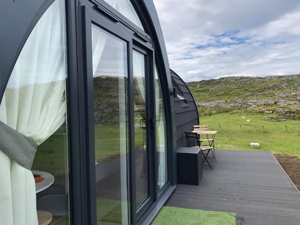 a view from the outside of a house with a deck at Sandy Meadow Escapes in Lairg