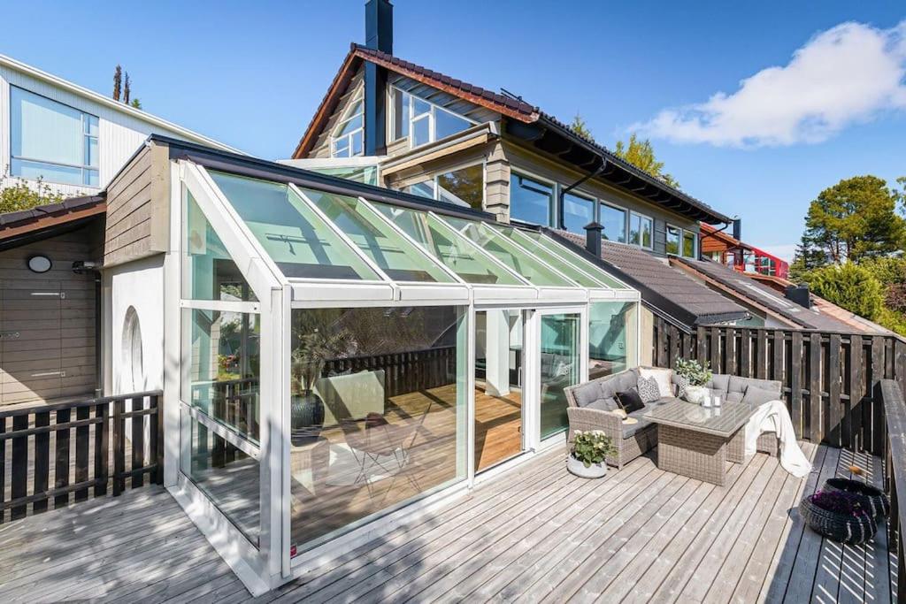 a patio with a glass extension on a house at 7 min to Ski Championship, Glass front house, Terrace in Trondheim