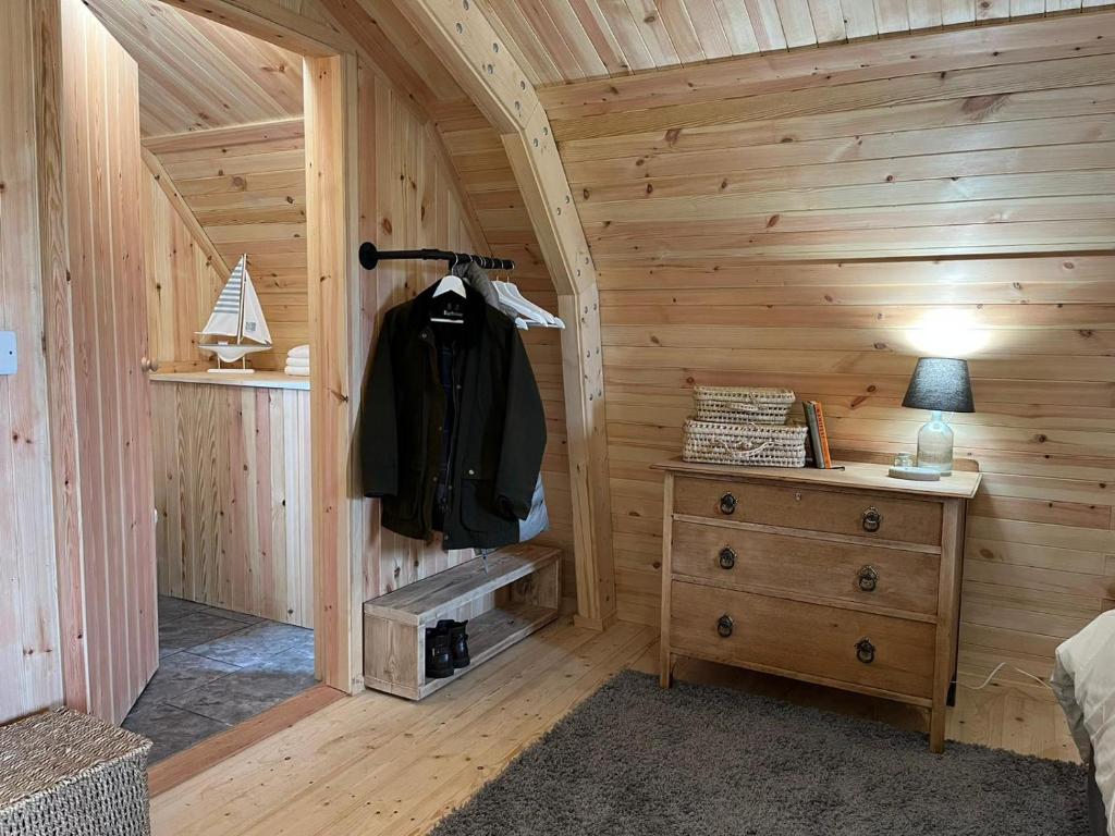 a wooden cabin with a backpack hanging on the wall at Sandy Meadow Escapes in Lairg