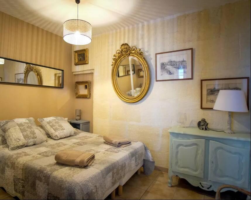 une chambre avec un lit et un miroir au mur dans l'établissement Le Forum Quartier La Roquette, à Arles