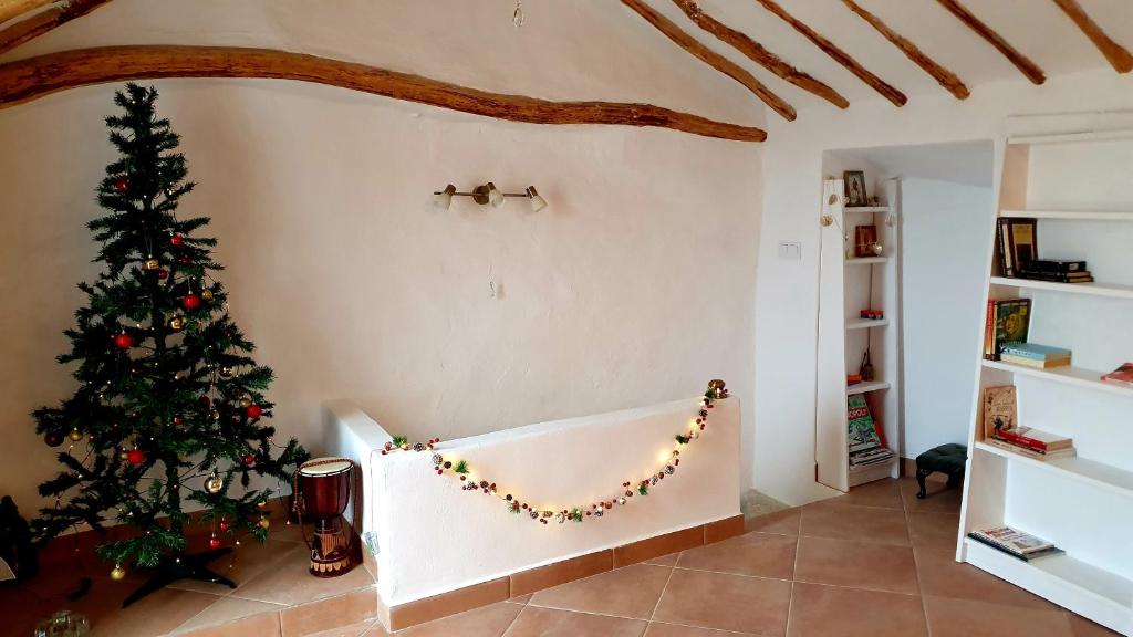 Una sala de estar con un árbol de Navidad en la esquina. en Casa Leto Rural, en Iznájar