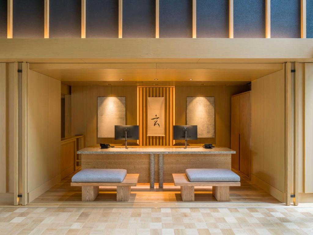 a lobby with two benches and a reception desk at Banyan Tree Higashiyama Kyoto in Kyoto