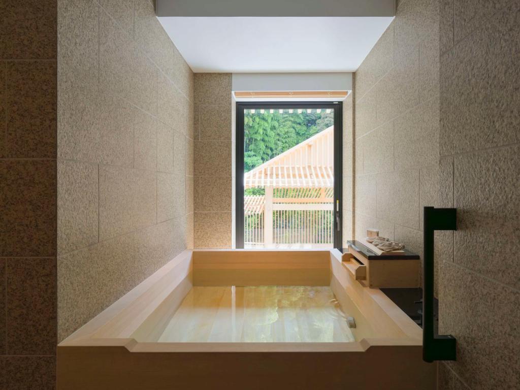 a room with a bath tub with a window at Banyan Tree Higashiyama Kyoto in Kyoto