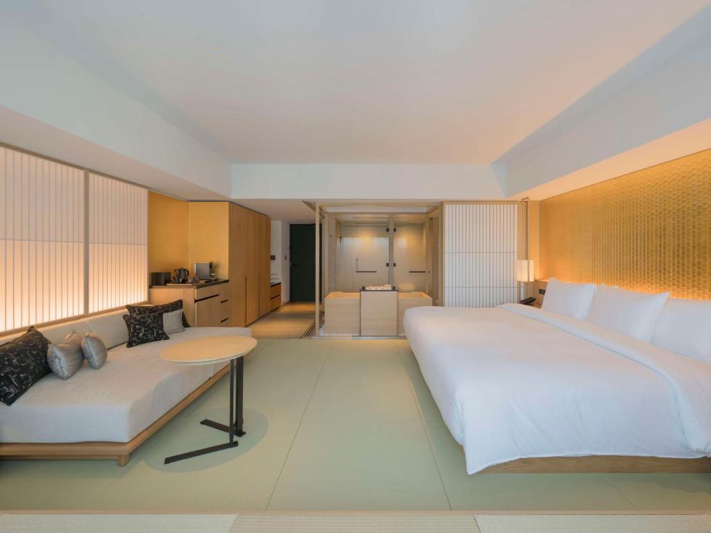 a bedroom with a large bed and a couch at Banyan Tree Higashiyama Kyoto in Kyoto