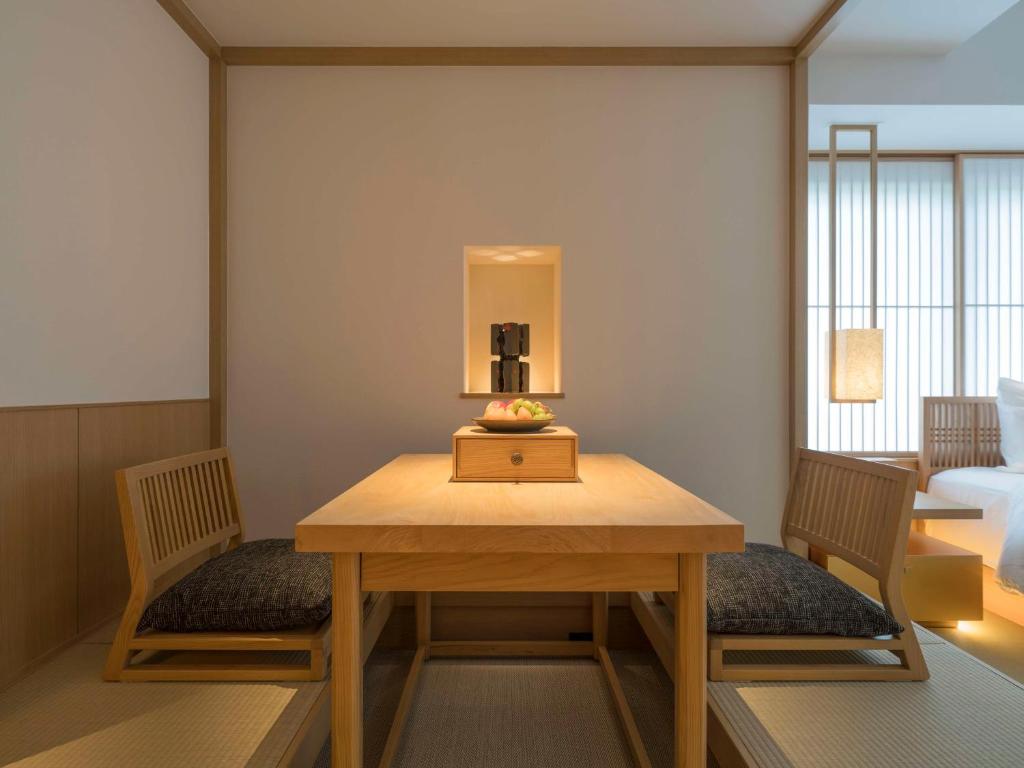 a room with a table and two chairs and a bed at Banyan Tree Higashiyama Kyoto in Kyoto