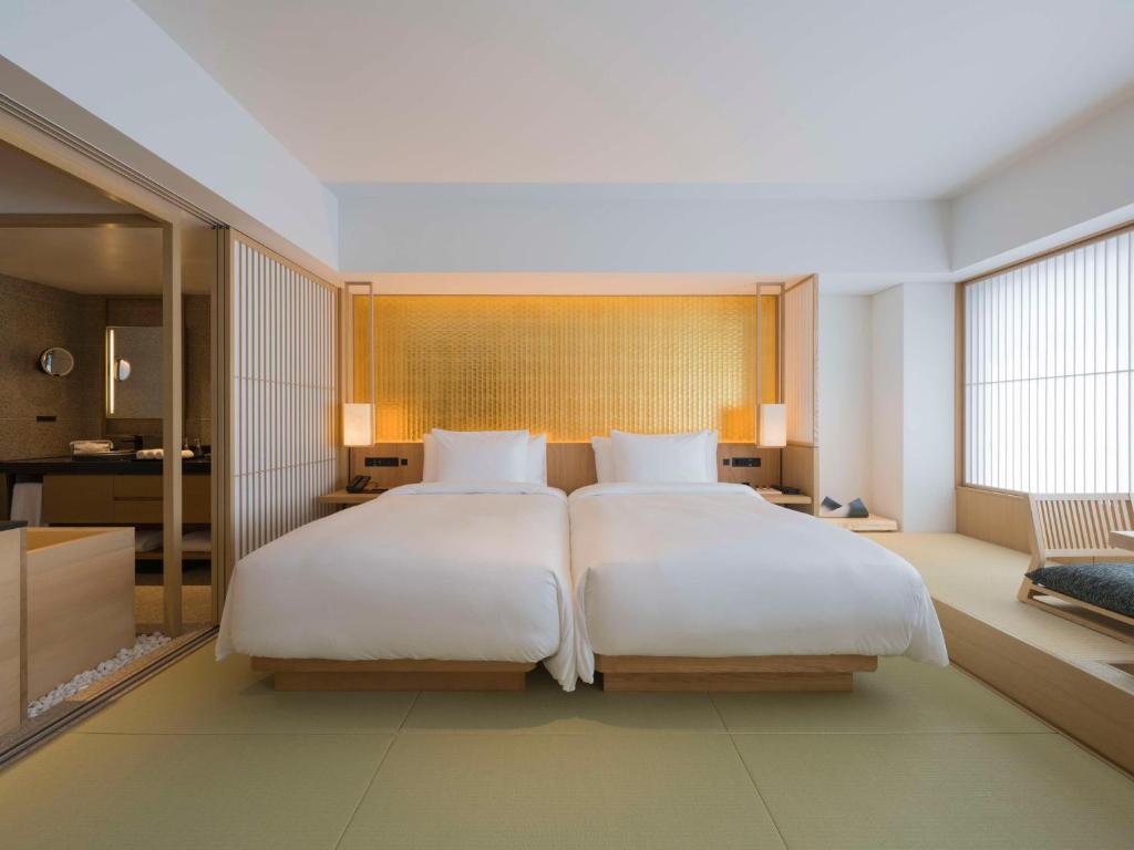a large bedroom with two beds and a large window at Banyan Tree Higashiyama Kyoto in Kyoto