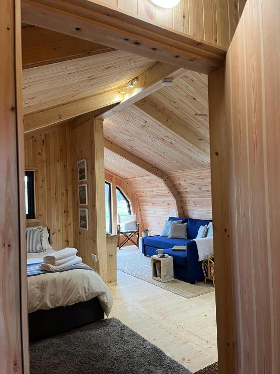 a room with a bed and a couch in a room at Sandy Meadow Escapes in Lairg