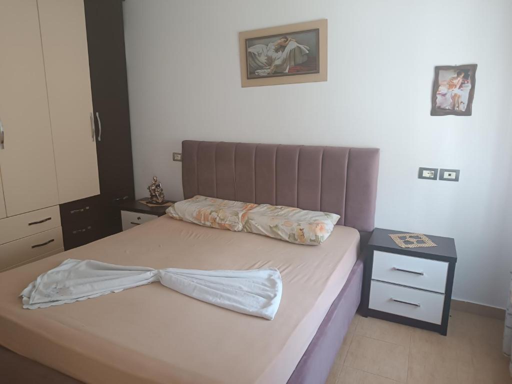 a bedroom with a bed with a bow tie on it at Apartament for Rent Elis in Berat