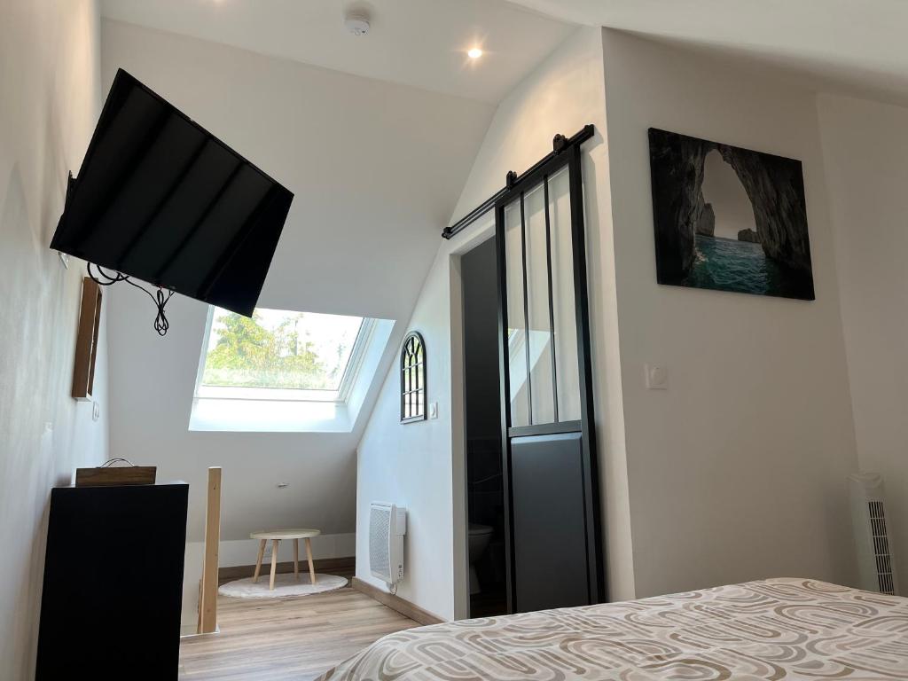 une chambre avec un lit et une télévision au mur dans l'établissement Suite parentale Courpalay, à Courpalay