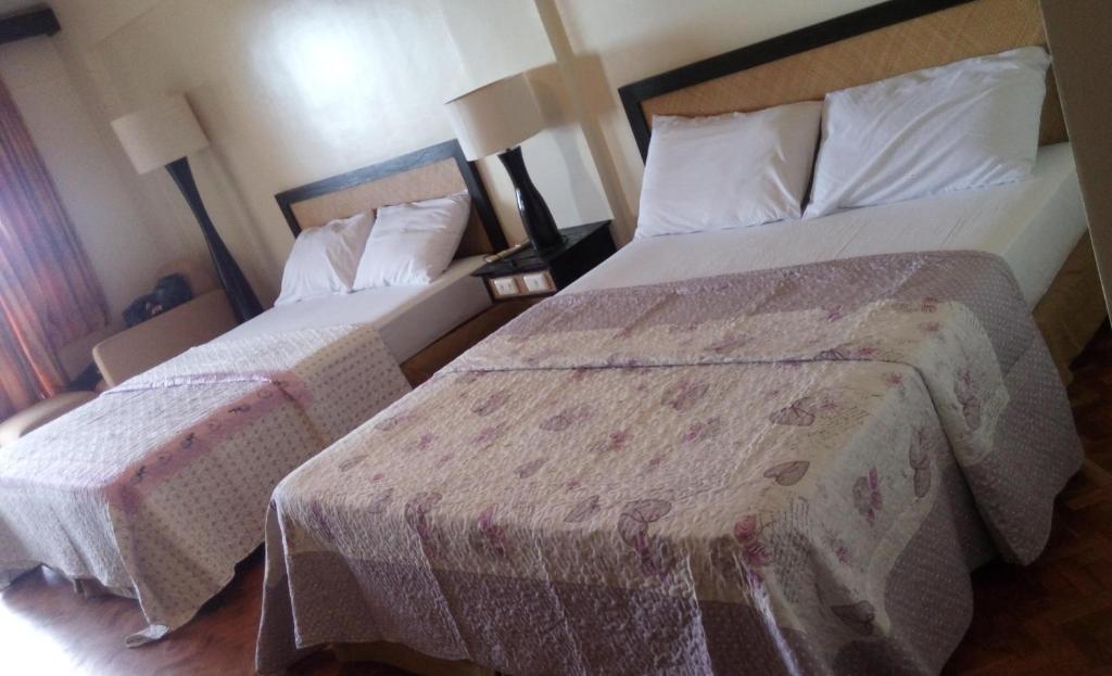 ein Hotelzimmer mit zwei Betten und zwei Lampen in der Unterkunft Paradise Apartment in Malay boracay philippines in Boracay