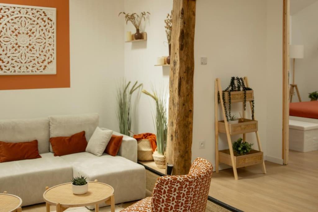 a living room with a couch and a table and chairs at La Halte de la tour in Warcq
