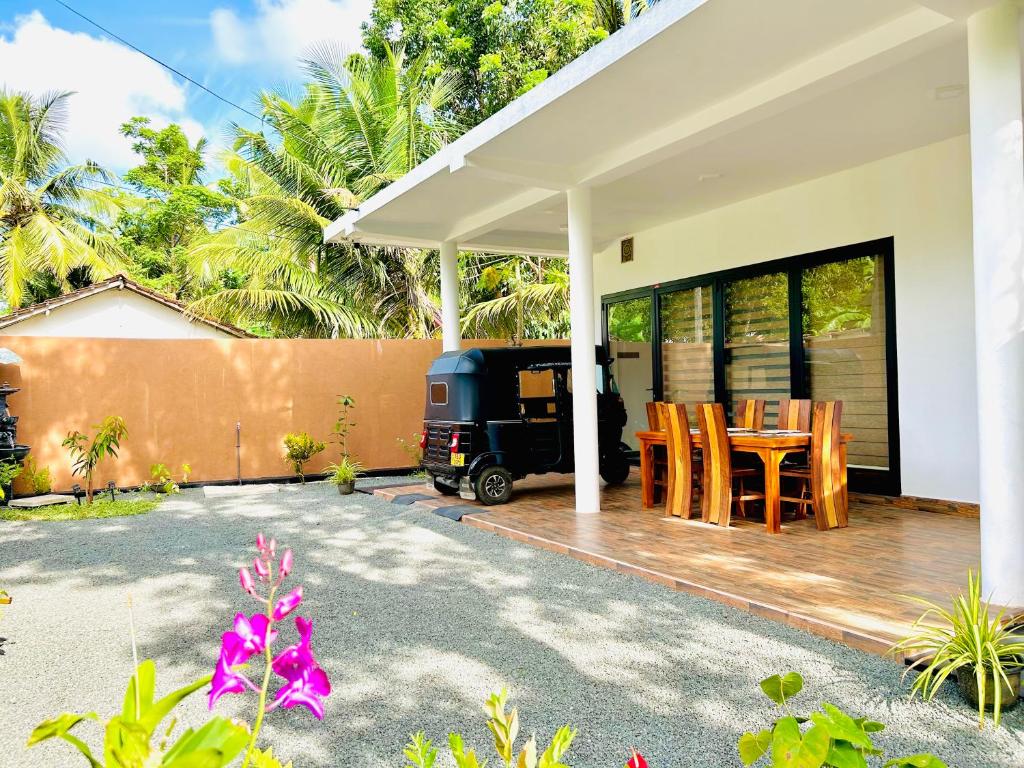 a house with a patio with a table and chairs at Villa Sara in Balapitiya