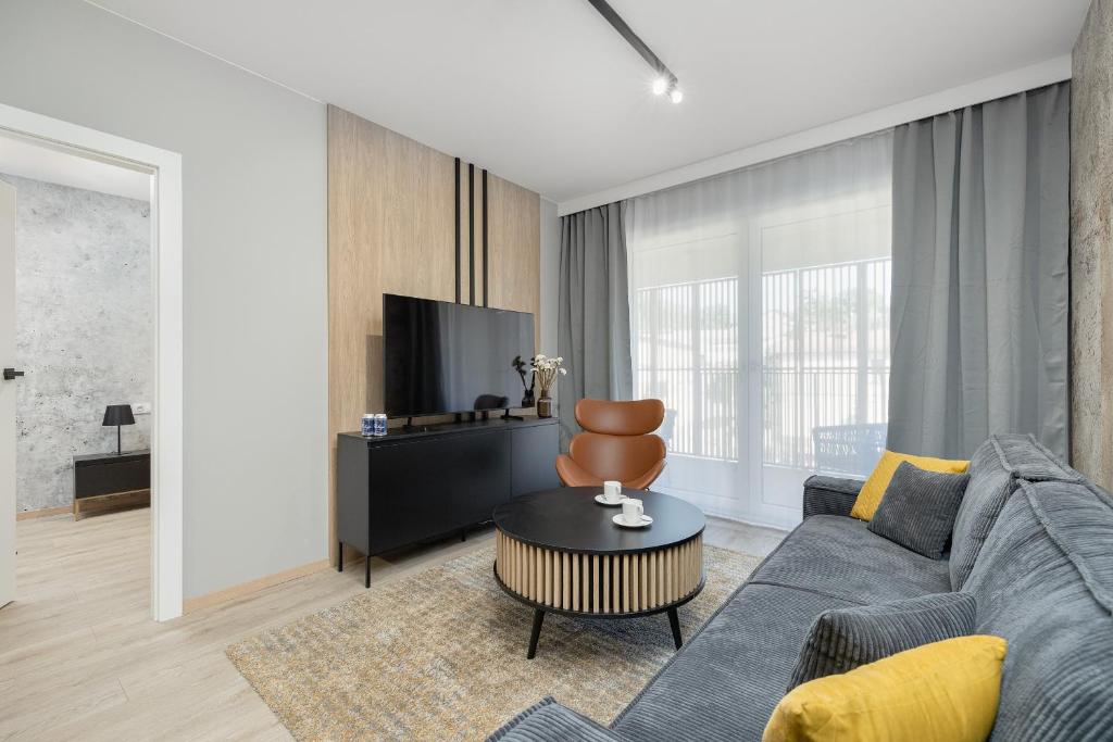 un salon avec un canapé et une table dans l'établissement Nowoczesny i Elegancki Apartament A212 z Balkonem i Parkingiem by Noclegi Renters, à Międzyzdroje