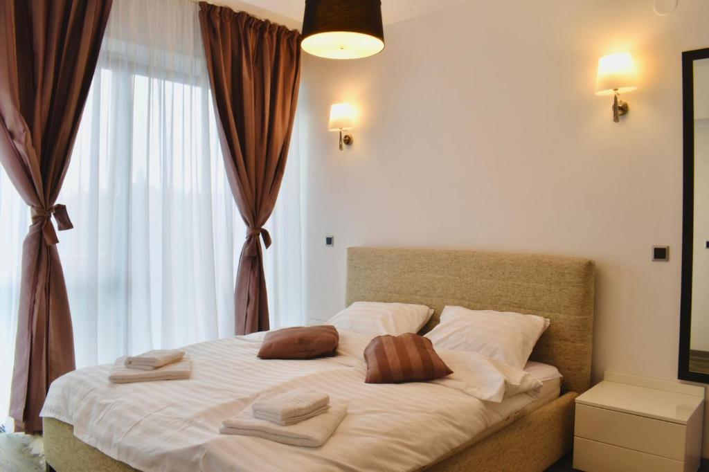a bedroom with a bed with two pillows on it at Apartament Silver Mountain Resort & Spa Poiana Brasov in Poiana Brasov