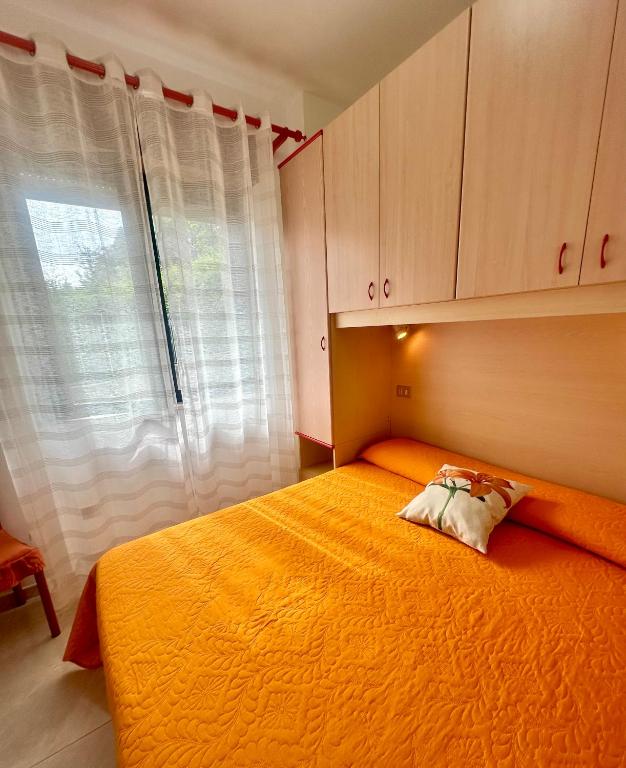a bedroom with a large orange bed with a window at Belvedere Home in Rodi Garganico