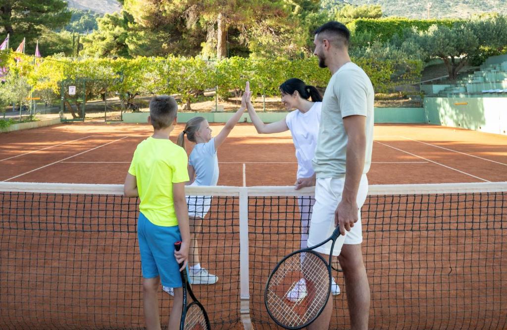 a group of people standing on a tennis court at Bluesun Holiday Village Bonaca - Full Board Plus in Bol