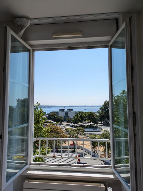 a window in a house with a view of the ocean at Hotel de la Gare Brest in Brest