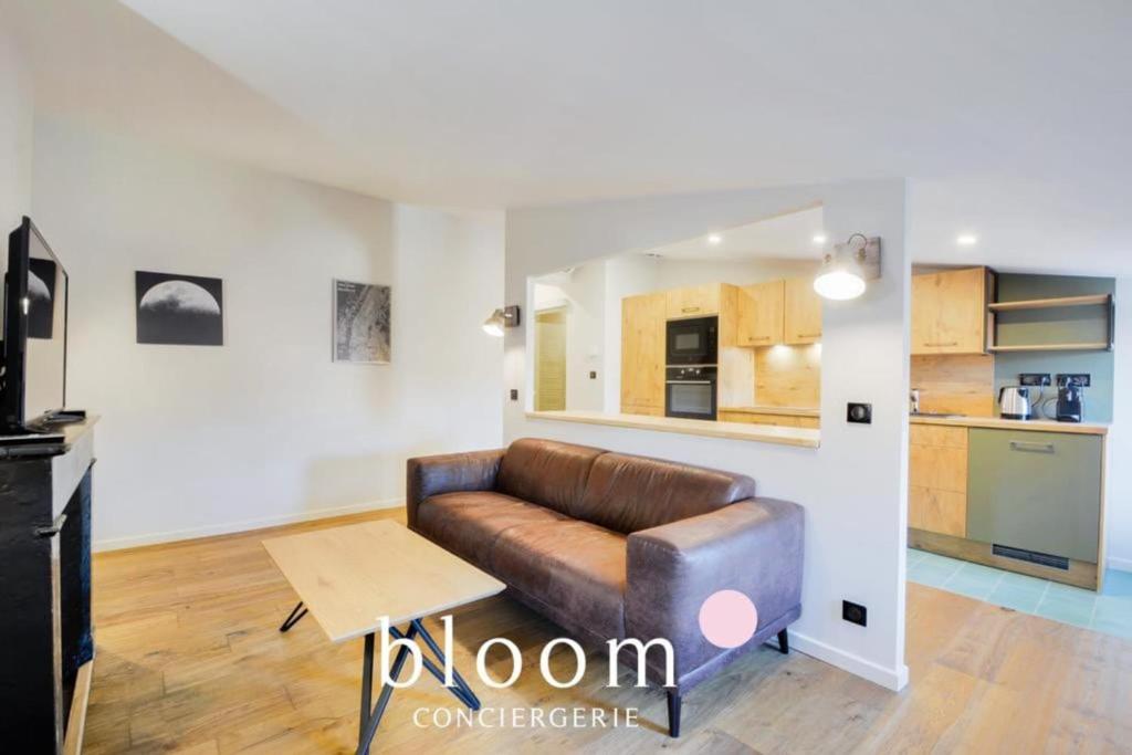 un salon avec un canapé en cuir et une cuisine dans l'établissement Nancy vieille ville bel appartement rénové, à Nancy