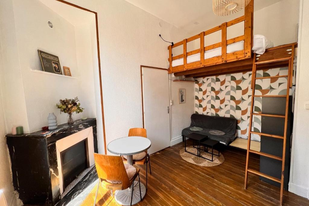 - un salon avec des lits superposés, une table et des chaises dans l'établissement Nancy Centre ville Studio rénové et équipé, à Nancy