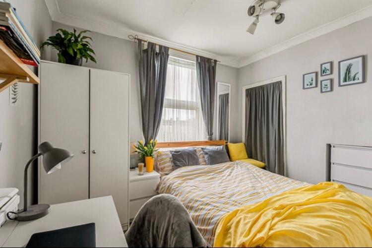 una camera da letto con un letto, una scrivania e una finestra di Lovely place a Londra