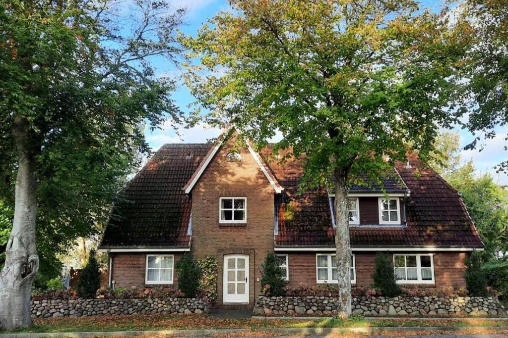 a red brick house with trees in front of it at Oberbremer, Heidweg 6 in Nieblum