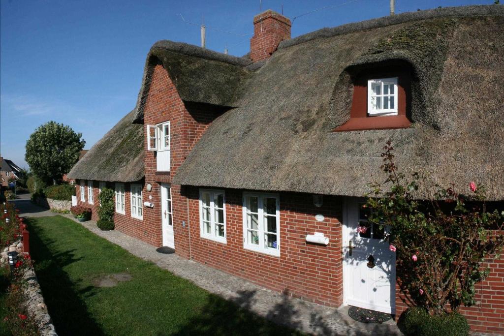 an old brick house with a thatched roof at Skriiwers Hüüs, Hausteil in Alkersum