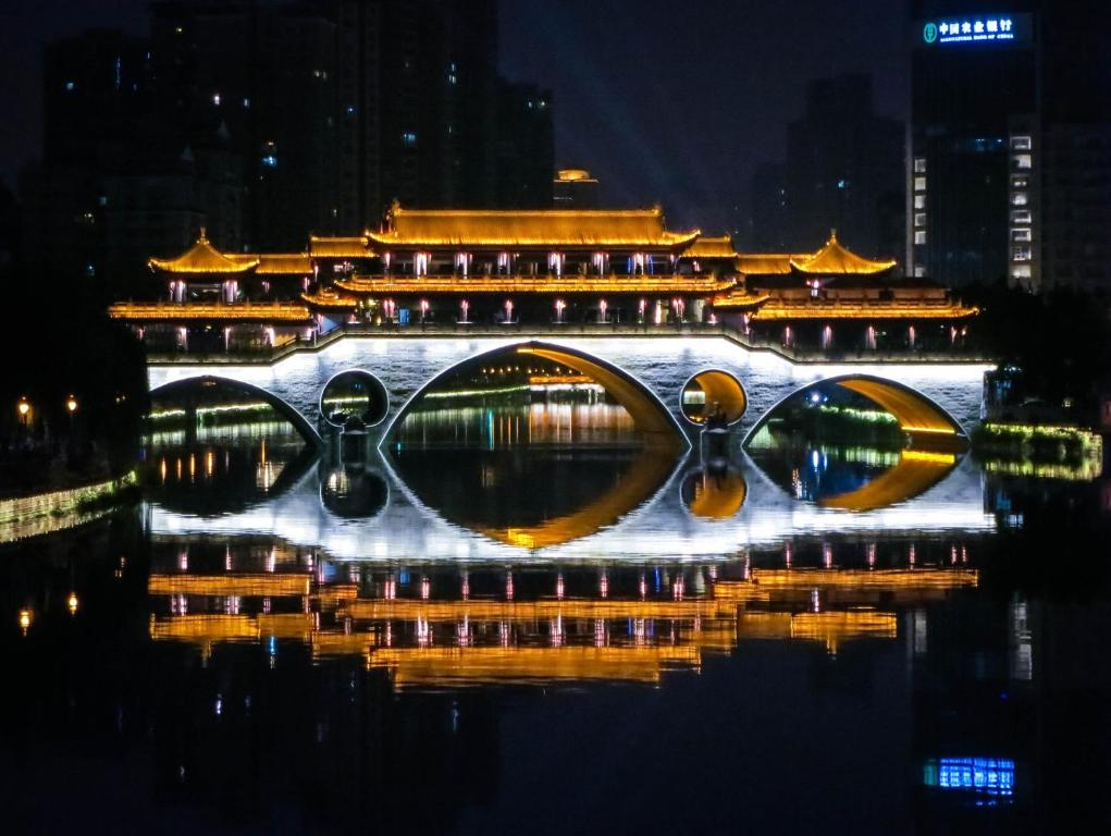 a bridge over a body of water at night at Nost algia S Hotel Near Chengdu Kuanzhai Alley - People's Park, Chengdu Panda Base, 10 minutes walk to subway , Free laundry, English communication well, Free coffee,Free travel advice in Chengdu