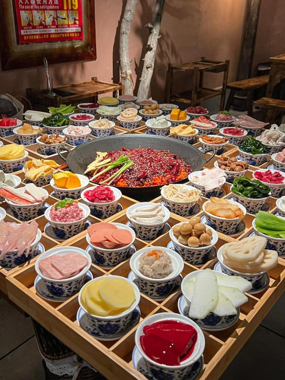 a table filled with lots of different types of food at Nost algia S Hotel Near Chengdu Kuanzhai Alley - People's Park, Chengdu Panda Base, 10 minutes walk to subway , Free laundry, English communication well, Free coffee,Free travel advice in Chengdu