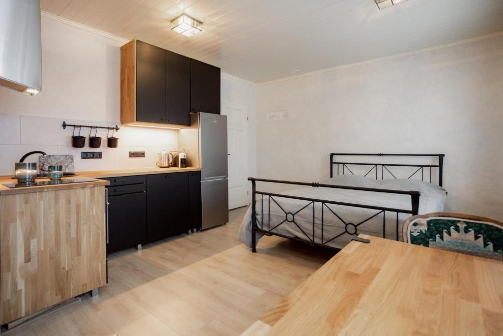 a kitchen with black cabinets and a wooden table at Von Aghte Small Studio in Kuressaare