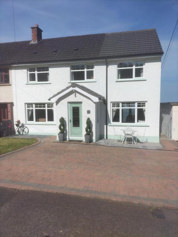 a white house with a patio in front of it at Ferns Holiday let in Glenarm