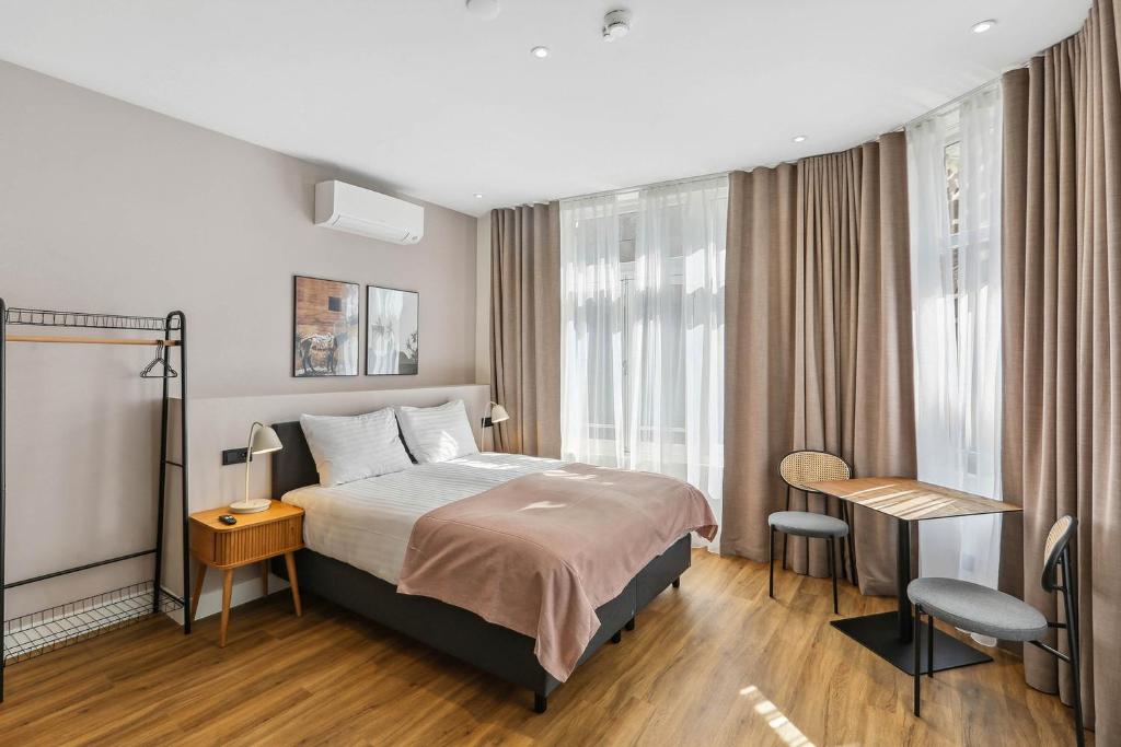 a hotel room with a bed and a desk and window at Limehome The Hague Nieuwstraat in The Hague