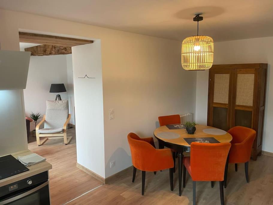 une cuisine et une salle à manger avec une table et des chaises dans l'établissement La Maisonnette des Grèves, 8 min du Mont St Michel, à Courtils