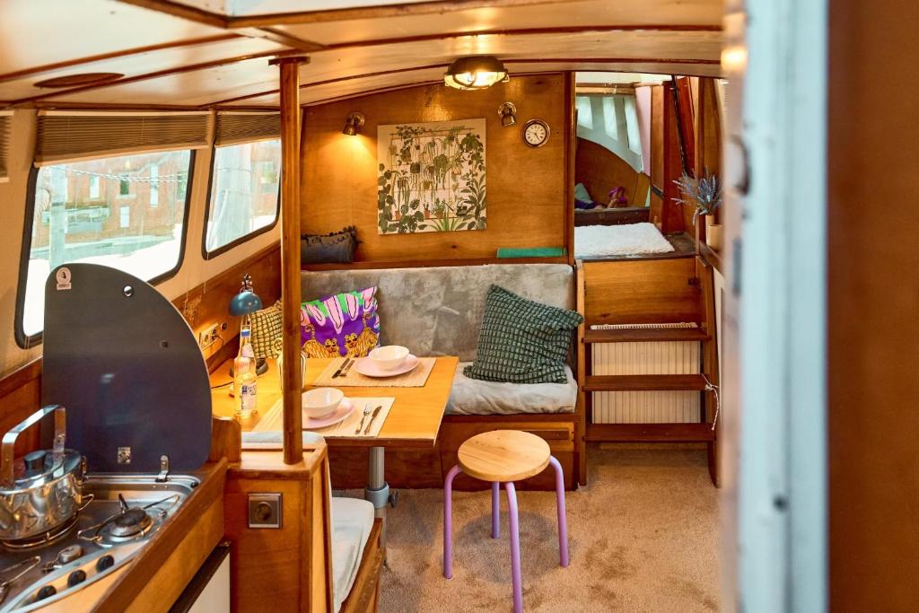 een keuken en eetkamer met een tafel in een camper bij Gemütliches Wohnschiff in Brandenburg an der Havel