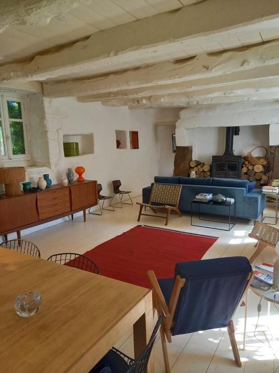 un salon avec un canapé bleu et une cheminée dans l'établissement Longere ancienne dans un parc, à Plogonnec