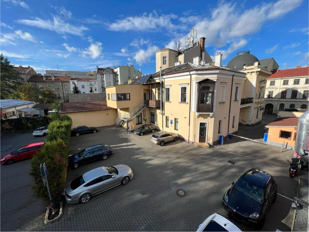 a parking lot with cars parked in front of a building at Palac Anežka D1 in Brno