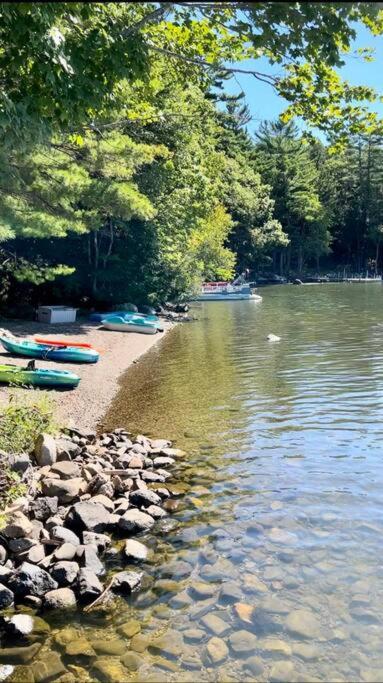 a body of water with boats on the shore at Lakefront Cottage on Brewer Lake in Holden