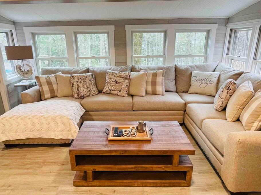 ein Wohnzimmer mit einer Couch und einem Couchtisch in der Unterkunft Lakefront Cottage on Brewer Lake in Holden